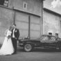 bridal couple posing in front of beautiful ford mustang