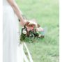 Bridal bouquet with copper leaves and various flowers.