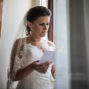 bride is reading a letter by the window